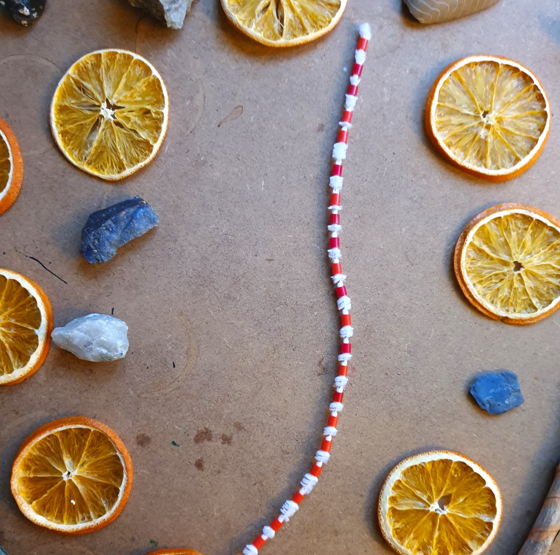 Trä pärlor på en piprensare, gärna med lite mellanrum mellan varje pärla.