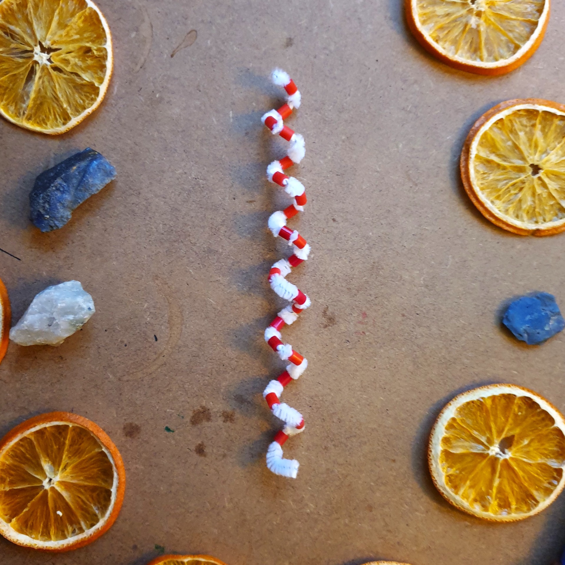 Färdig spiral med pärlor – liggande på bord med torkade apelsinskivor
