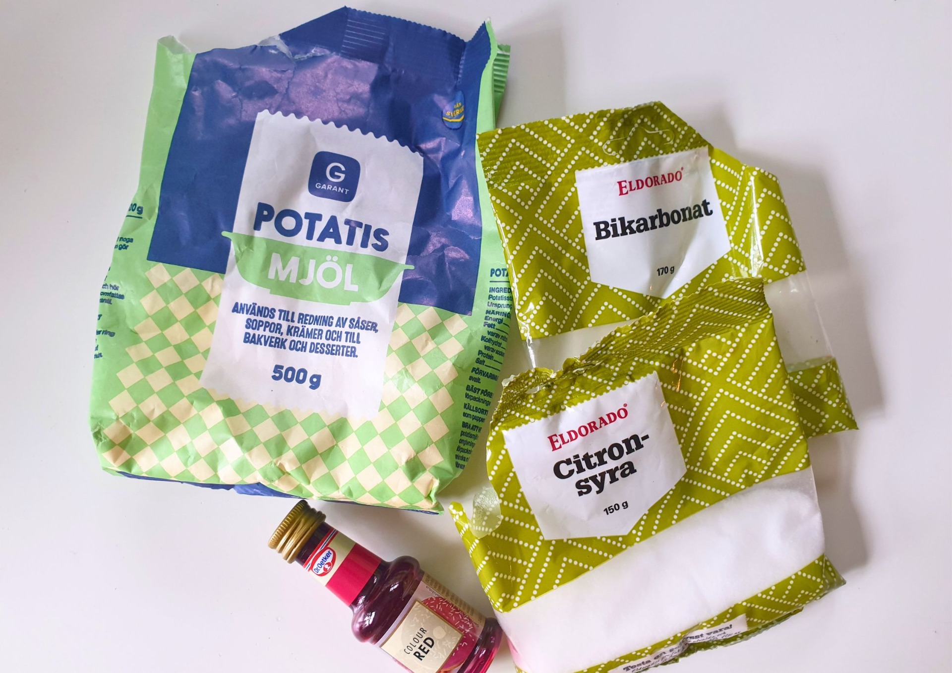 Ingredienser till magiskt pulver med bikarbonat, citronsyra, potatismjöl och karamellfärg.